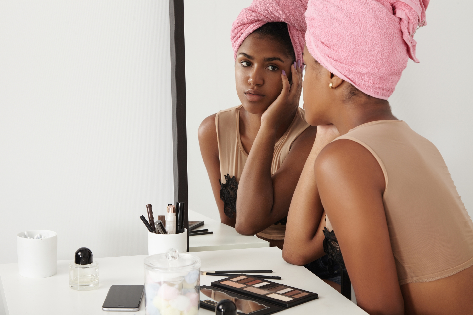 Woman applying makeup in front of a mirror